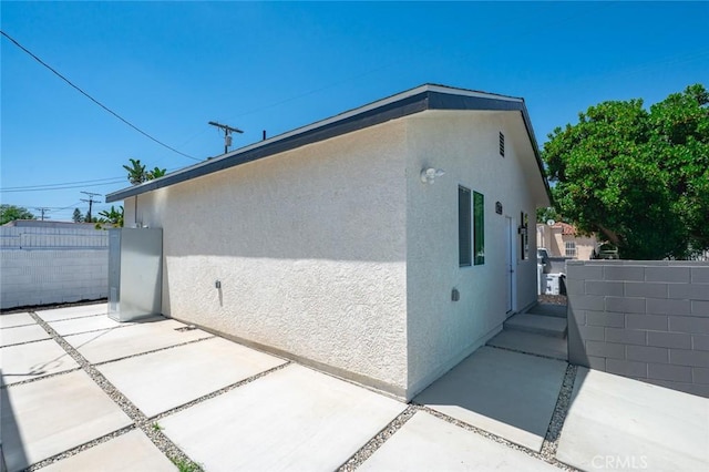 2101 W 76th St, Los Angeles, CA 90047 - view of side of home with stucco siding and a patio area