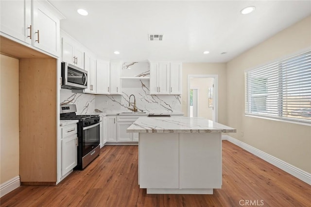 2101 W 76th St, Los Angeles, CA 90047 - kitchen with stainless steel appliances, baseboards, decorative backsplash, a center island, and recessed lighting