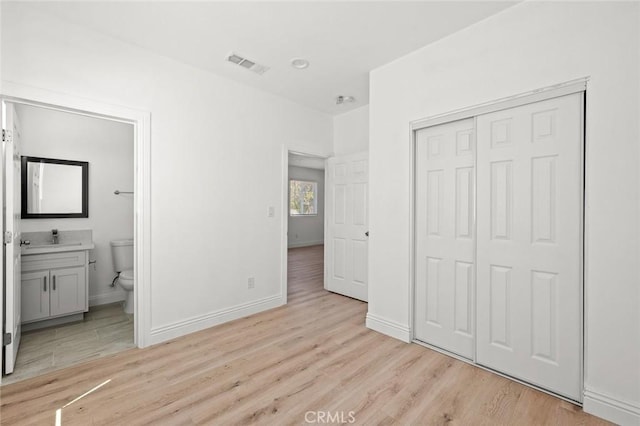 2101 W 76th St, Los Angeles, CA 90047 - unfurnished bedroom with light wood-type flooring, a closet, and ensuite bathroom