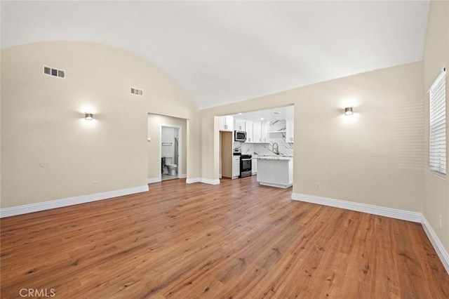 2101 W 76th St, Los Angeles, CA 90047 - unfurnished living room featuring lofted ceiling, baseboards, light wood-style floors, and a sink