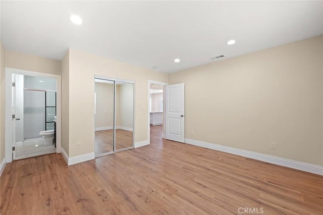2101 W 76th St, Los Angeles, CA 90047 - unfurnished bedroom with a closet, baseboards, light wood finished floors, recessed lighting, and ensuite bathroom