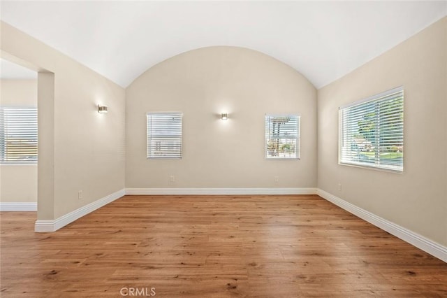 2101 W 76th St, Los Angeles, CA 90047 - unfurnished room featuring baseboards, light wood finished floors, and vaulted ceiling