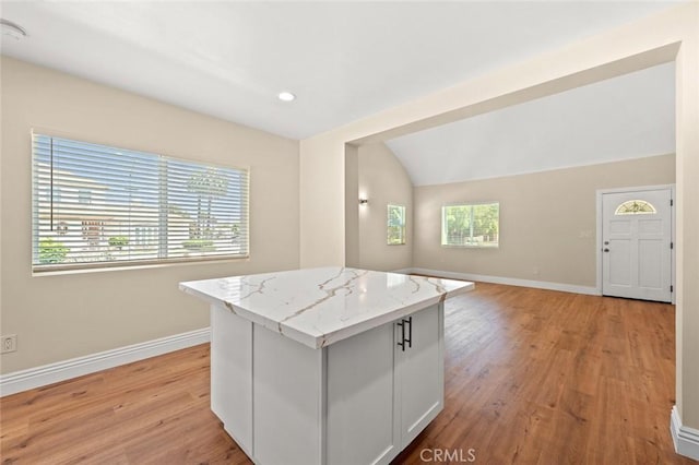 2101 W 76th St, Los Angeles, CA 90047 - kitchen featuring open floor plan, a center island, light wood finished floors, baseboards, and light stone countertops