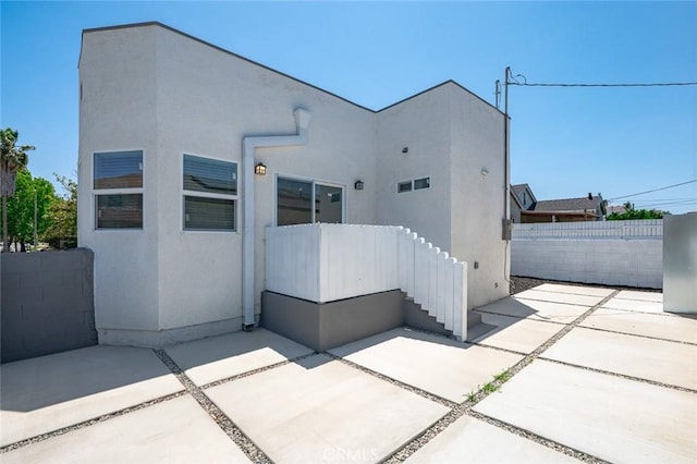 2101 W 76th St, Los Angeles, CA 90047 - rear view of house with a patio area, a fenced backyard, and stucco siding