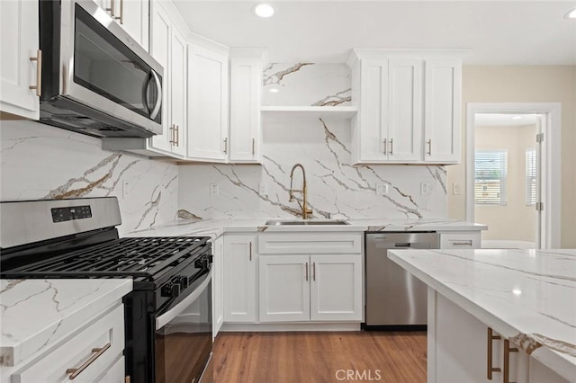 2101 W 76th St, Los Angeles, CA 90047 - kitchen with appliances with stainless steel finishes, a sink, white cabinets, decorative backsplash, and recessed lighting