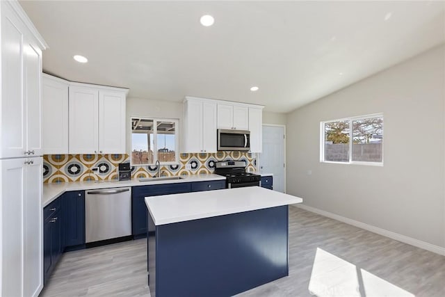 5951 Rose Ellen Ave Unit 29, Palms, CA 92277 - kitchen with appliances with stainless steel finishes, a sink, blue cabinetry, tasteful backsplash, and light countertops