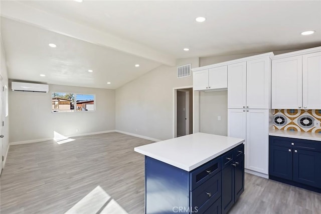 5951 Rose Ellen Ave Unit 29, Palms, CA 92277 - kitchen featuring a wall unit AC, blue cabinets, light wood-style floors, white cabinetry, and recessed lighting