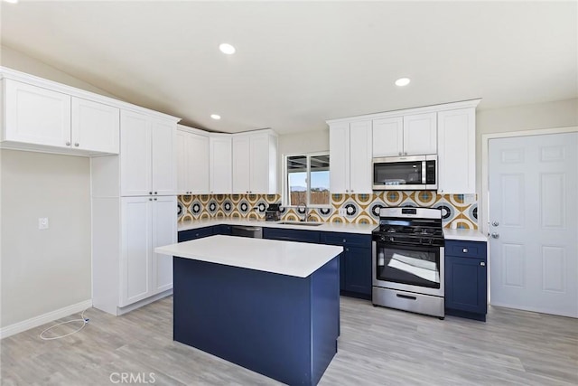 5951 Rose Ellen Ave Unit 29, Palms, CA 92277 - kitchen with stainless steel appliances, blue cabinetry, a sink, light wood-type flooring, and backsplash