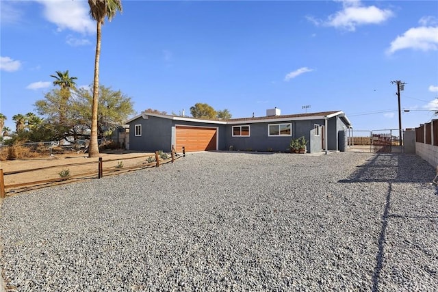 5951 Rose Ellen Ave Unit 29, Palms, CA 92277 - view of front facade with a garage and gravel driveway