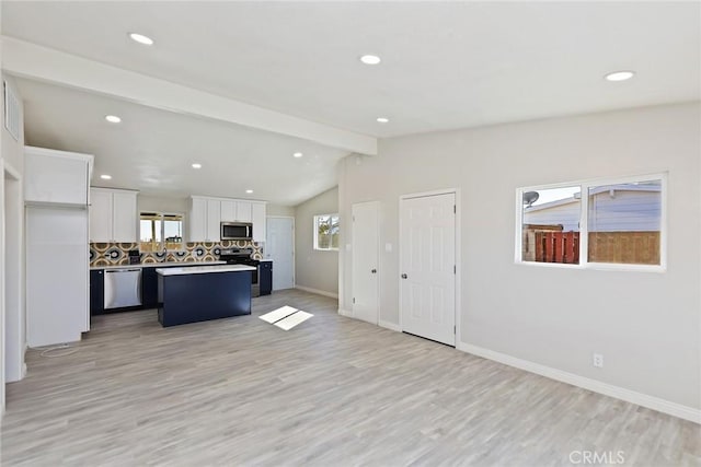 5951 Rose Ellen Ave Unit 29, Palms, CA 92277 - kitchen with stainless steel appliances, a center island, white cabinetry, tasteful backsplash, and light wood finished floors