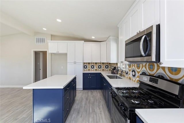 5951 Rose Ellen Ave Unit 29, Palms, CA 92277 - kitchen featuring stainless steel appliances, blue cabinets, a sink, light wood-style floors, and white cabinets