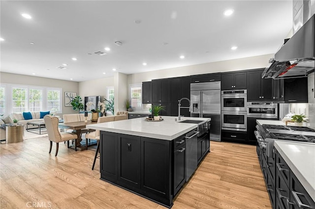 62 Pelican Ln, Irvine, CA 92618 - kitchen featuring dark cabinetry, stainless steel appliances, wall chimney exhaust hood, and recessed lighting