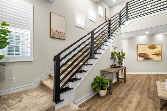 62 Pelican Ln, Irvine, CA 92618 - staircase featuring baseboards, wood finished floors, and a high ceiling
