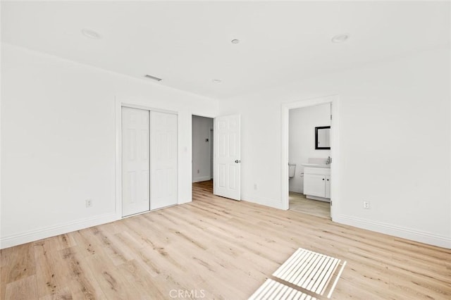 939 E 97th St, Los Angeles, CA 90002 - unfurnished bedroom with light wood finished floors, a closet, baseboards, and ensuite bath