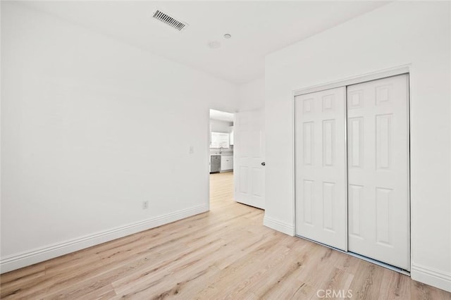 939 E 97th St, Los Angeles, CA 90002 - unfurnished bedroom featuring light wood finished floors, a closet, and baseboards