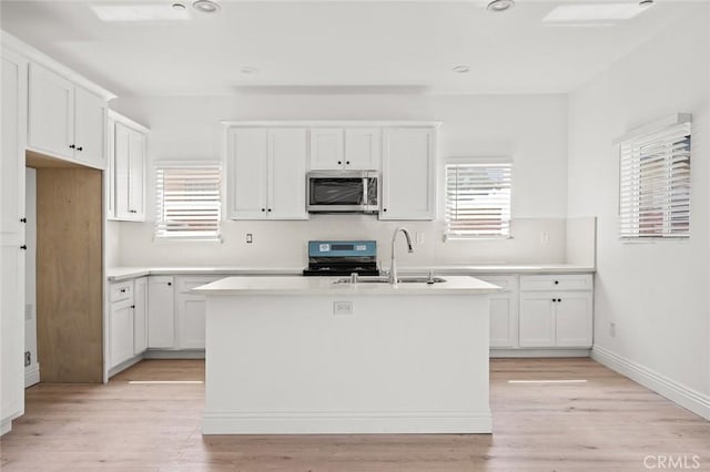 939 E 97th St, Los Angeles, CA 90002 - kitchen featuring appliances with stainless steel finishes, a sink, a kitchen island with sink, white cabinets, and recessed lighting