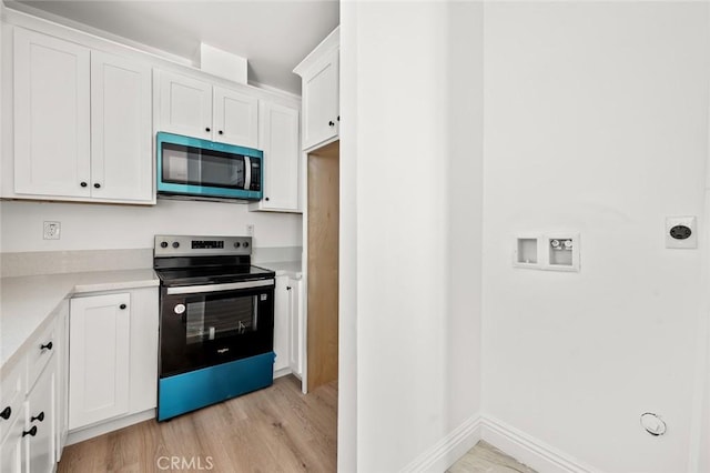 939 E 97th St, Los Angeles, CA 90002 - kitchen with stainless steel appliances, light wood-type flooring, white cabinets, light countertops, and baseboards