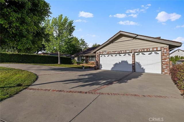 11180 Bertrand Ave, Granada Hills, CA 91344 - ranch-style home with concrete driveway, brick siding, and an attached garage