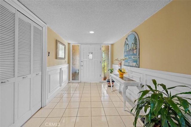 11180 Bertrand Ave, Granada Hills, CA 91344 - entryway with a textured ceiling, a decorative wall, light tile patterned flooring, and a wainscoted wall