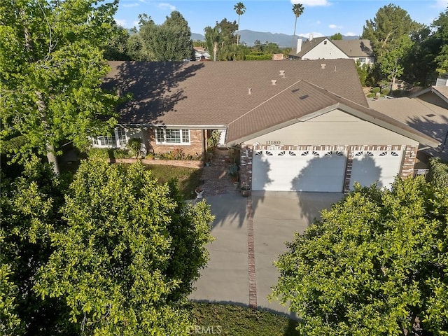 11180 Bertrand Ave, Granada Hills, CA 91344 - view of front of home with driveway, brick siding, an attached garage, and roof with shingles