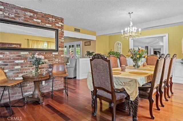 11180 Bertrand Ave, Granada Hills, CA 91344 - dining space featuring a textured ceiling, hardwood / wood-style flooring, and a chandelier