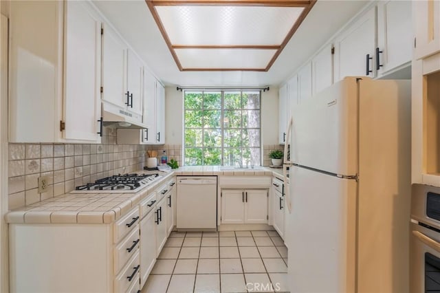 1375 Kelton Ave Unit 104, Los Angeles, CA 90024 - kitchen featuring white appliances, under cabinet range hood, tile countertops, and backsplash