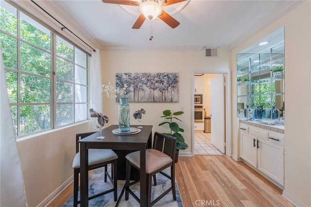 1375 Kelton Ave Unit 104, Los Angeles, CA 90024 - dining room with light wood-style flooring, healthy amount of natural light, ornamental molding, a ceiling fan, and baseboards
