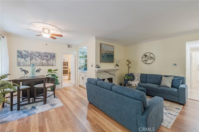 1375 Kelton Ave Unit 104, Los Angeles, CA 90024 - living room featuring a ceiling fan, light wood-style flooring, crown molding, and a fireplace