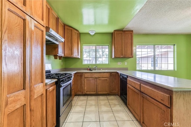 17415 Minnehaha St, Granada Hills, CA 91344 - kitchen with stainless steel range with gas cooktop, under cabinet range hood, black dishwasher, a peninsula, and brown cabinets