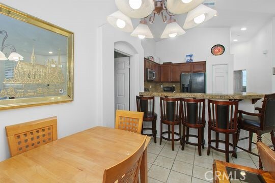 4516 Streamport Dr, Riverside, CA 92505 - dining room with light tile patterned floors, arched walkways, and a chandelier