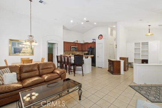 4516 Streamport Dr, Riverside, CA 92505 - living room with high vaulted ceiling, light tile patterned floors, a chandelier, recessed lighting, and arched walkways