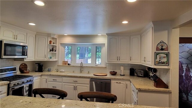 221 Darfo Dr, Crestline, CA 92325 - kitchen with appliances with stainless steel finishes, a sink, white cabinetry, decorative backsplash, and recessed lighting