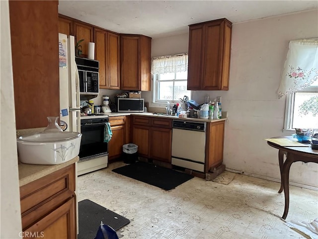 4058 Bledsoe Ave, Culver City, CA 90066 - kitchen with dishwasher, stove, stainless steel microwave, brown cabinetry, and light countertops