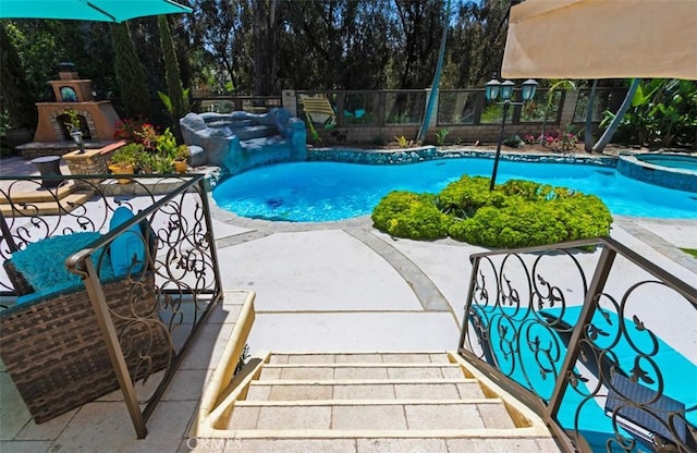 27773 Hidden Trail Rd, Laguna Hills, CA 92653 - view of swimming pool with a patio, a pool with connected hot tub, exterior fireplace, and view of wooded area