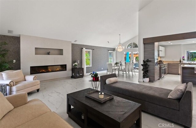 27773 Hidden Trail Rd, Laguna Hills, CA 92653 - living area with light marble finish floors, a fireplace, a chandelier, and a towering ceiling
