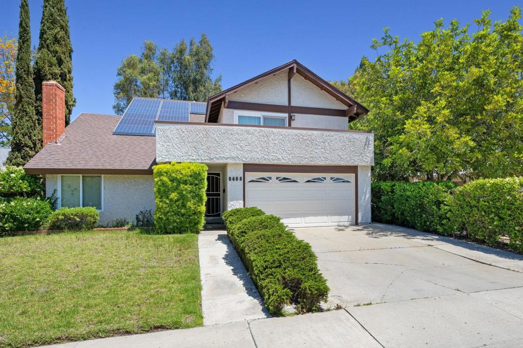 8468 Calle Morelos, San Diego, CA 92126 - view of front facade with driveway, a chimney, roof mounted solar panels, a front yard, and roof with shingles