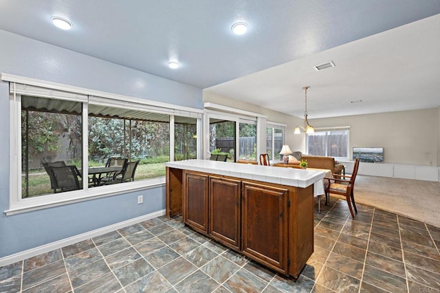 8468 Calle Morelos, San Diego, CA 92126 - kitchen featuring tile countertops, decorative light fixtures, open floor plan, baseboards, and dark brown cabinets