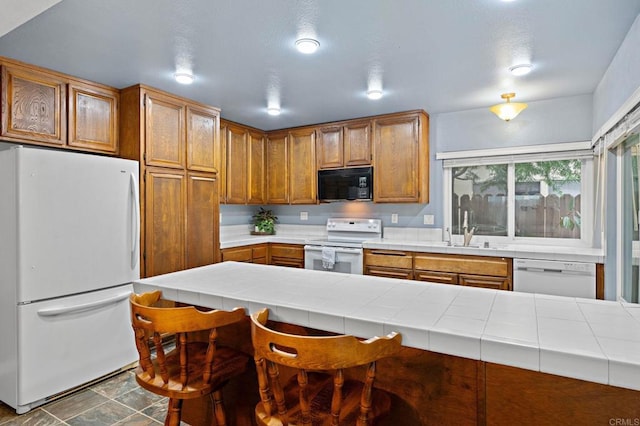 8468 Calle Morelos, San Diego, CA 92126 - kitchen with white appliances, tile countertops, and brown cabinetry