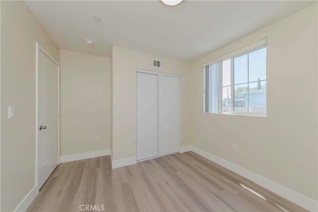 8711 Mckinley Pl, Los Angeles, CA 90002 - unfurnished bedroom with light wood-style flooring, a closet, and baseboards