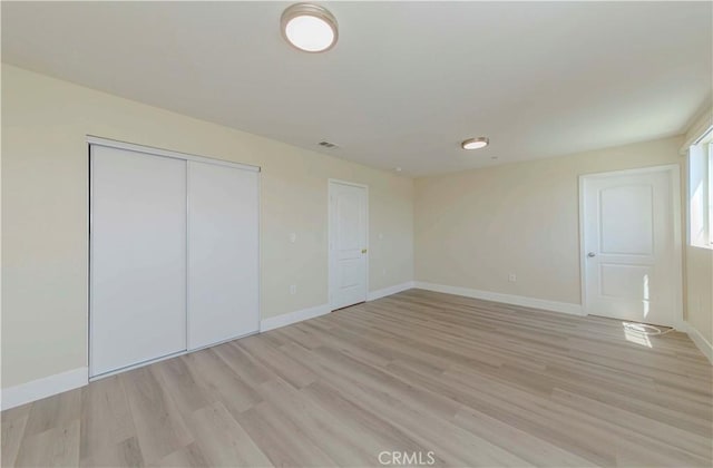8711 Mckinley Pl, Los Angeles, CA 90002 - unfurnished bedroom featuring light wood finished floors, a closet, and baseboards