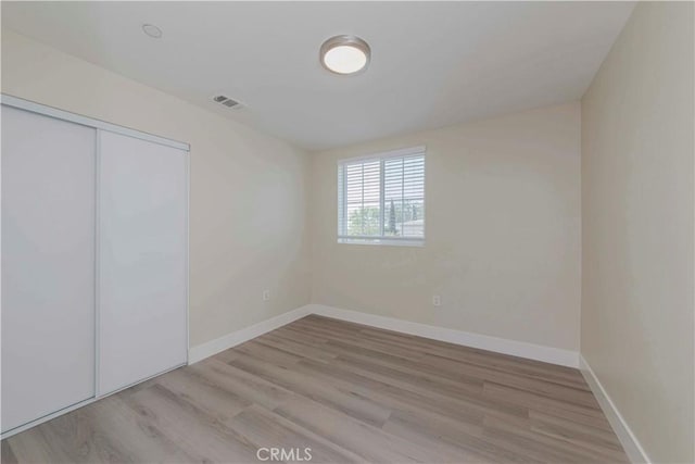 8711 Mckinley Pl, Los Angeles, CA 90002 - unfurnished bedroom with light wood-style floors, baseboards, and a closet
