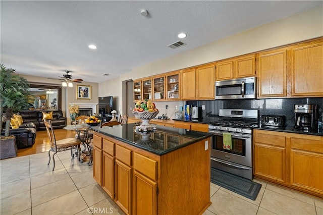 39243 Nicole Dr, Palmdale, CA 93551 - kitchen with appliances with stainless steel finishes, light tile patterned floors, a center island, open floor plan, and a ceiling fan