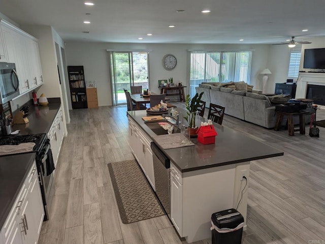 34885 Heartland Ln, Murrieta, CA 92563 - kitchen with appliances with stainless steel finishes, dark countertops, open floor plan, and recessed lighting