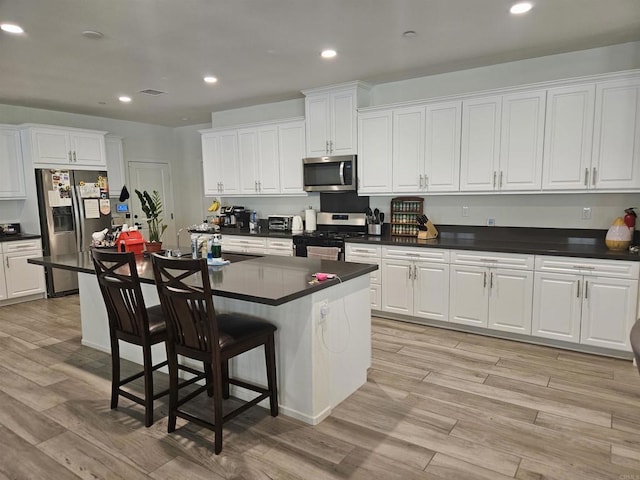 34885 Heartland Ln, Murrieta, CA 92563 - kitchen featuring appliances with stainless steel finishes, dark countertops, white cabinets, and recessed lighting