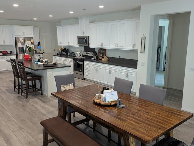 34885 Heartland Ln, Murrieta, CA 92563 - kitchen featuring appliances with stainless steel finishes, dark countertops, a kitchen island, white cabinets, and recessed lighting