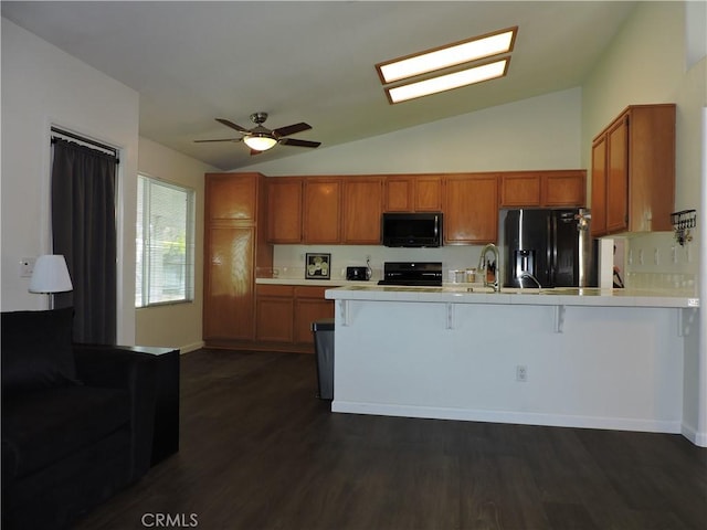 1326 Janes Way, Colton, CA 92324 - kitchen with black appliances, a peninsula, vaulted ceiling, brown cabinets, and a breakfast bar