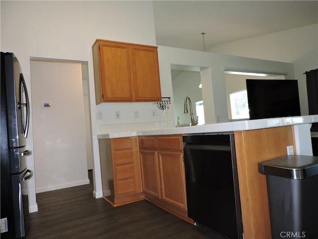 1326 Janes Way, Colton, CA 92324 - kitchen featuring freestanding refrigerator, black dishwasher, dark wood-type flooring, a peninsula, and brown cabinetry