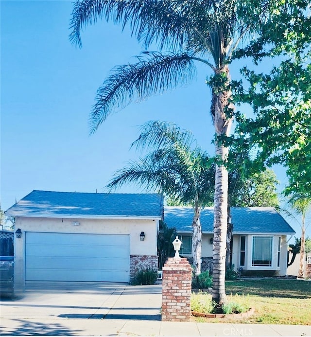 20554 Valerio St, Winnetka, CA 91306 - ranch-style house featuring an attached garage, concrete driveway, brick siding, a front lawn, and stucco siding