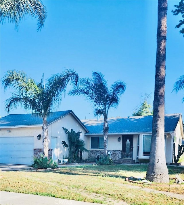 20554 Valerio St, Winnetka, CA 91306 - ranch-style house with stucco siding, an attached garage, a front yard, and stone siding