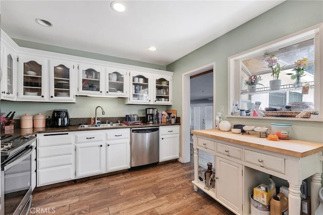 20554 Valerio St, Winnetka, CA 91306 - kitchen with appliances with stainless steel finishes, white cabinetry, glass insert cabinets, light wood-style flooring, and recessed lighting